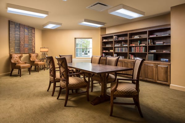 Cozy library with a large wooden table and bookshelves.