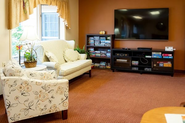 Comfortable seating in a living room with a television and bookshelf.