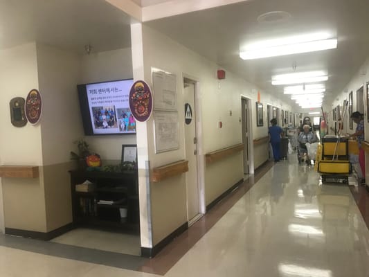 Busy hallway in assisted living facility with staff and residents
