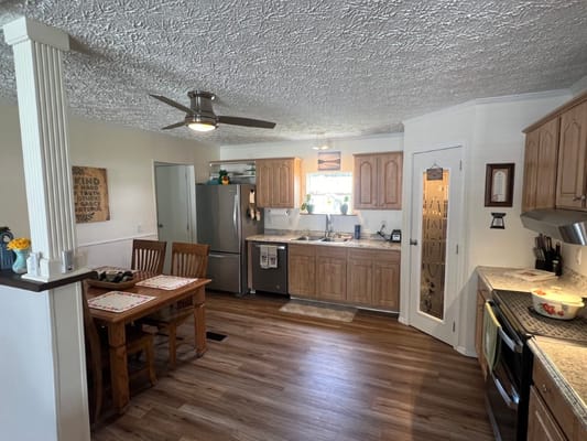 Bright kitchen area with wooden cabinets and dining table