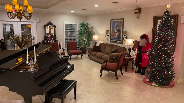 Lobby decorated for the holidays with a piano, couch, and Christmas tree