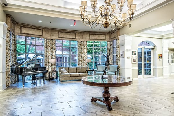 Bright interior common area with a piano and seating