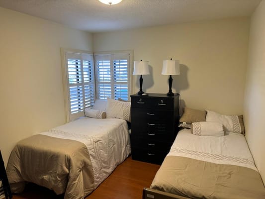 A cozy shared bedroom with two beds and natural light
