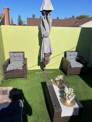 Outdoor seating area with umbrella and greenery