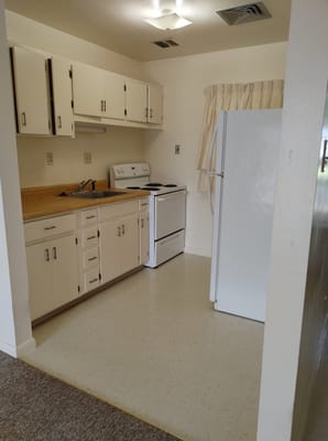 Bright kitchen with white appliances and wooden countertops.