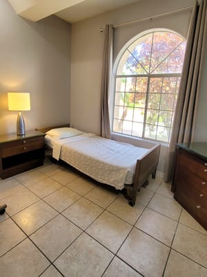 A private resident room with a bed and window