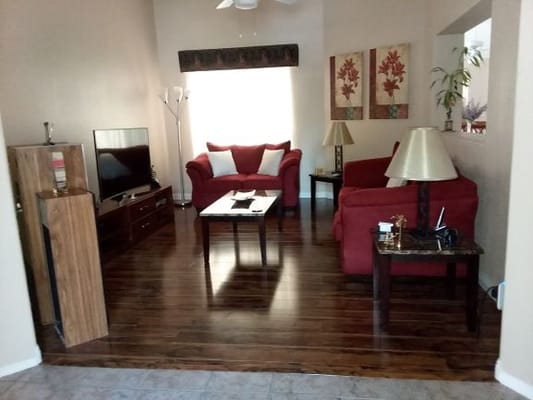Living room with red couches and wooden flooring
