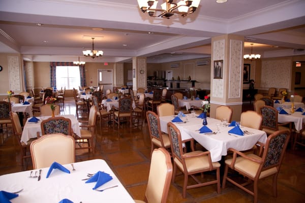 Well-decorated dining room with tables set for residents