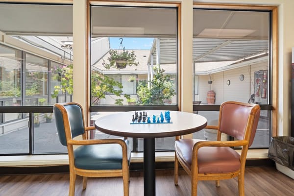Chairs and chess set in a common area with outdoor view