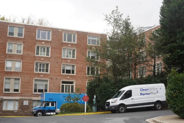 Exterior view of the facility building with vans parked