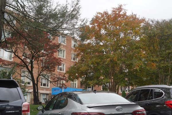 Exterior view of a senior living facility with fall foliage