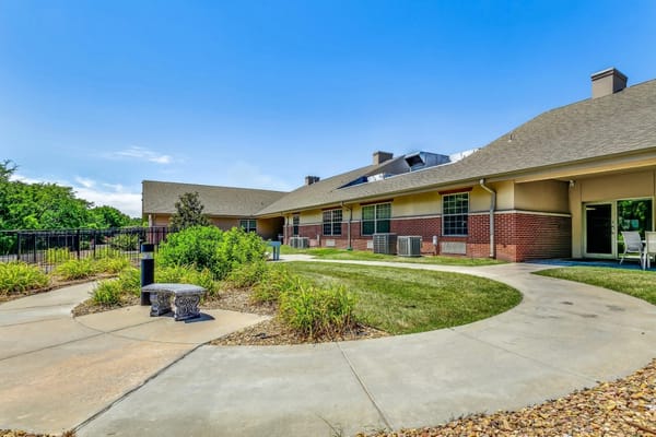 A garden area with seating and walking paths at Family Health & Rehab.