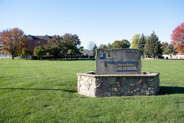 Stone sign of Valley View Village in a grassy area