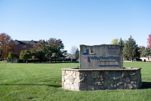 Sign for Valley View Village, a senior living facility, surrounded by green grass.