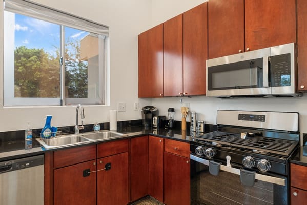 A modern kitchen with stainless steel appliances and wooden cabinets.