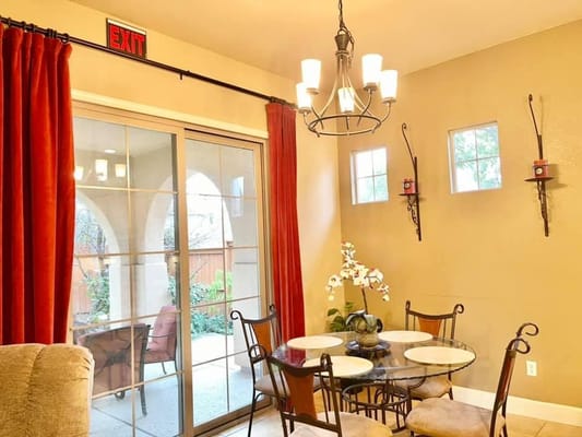 Dining table with chairs and decorative plants in a warm dining area.