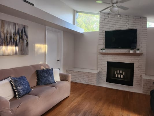 Bright and airy common area with a sofa and fireplace