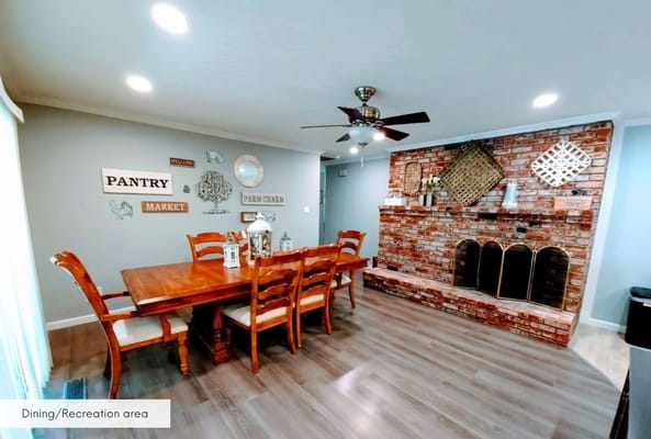 Dining area with wooden table and brick fireplace