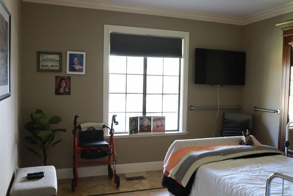 A senior room with personal photos and a walker