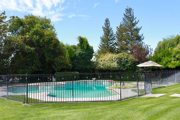 Well-maintained outdoor pool area surrounded by trees