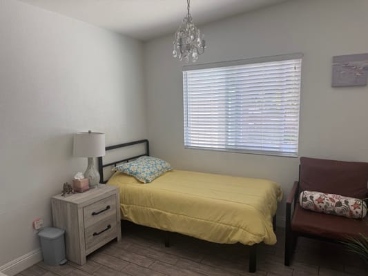 Cozy resident room with a yellow bedspread and a lamp