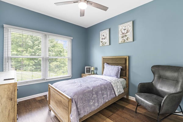 Cozy private resident room with blue walls and natural light