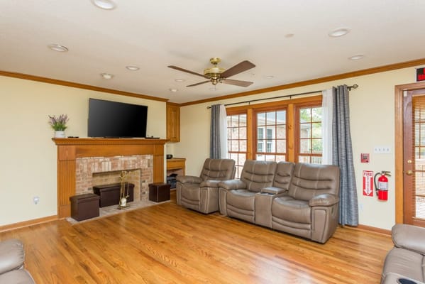 Spacious living room with brown leather reclining chairs and a fireplace