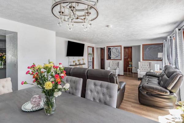 Spacious living room with leather couches and floral arrangements