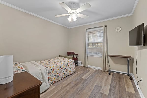 Cozy resident room with floral bedding and TV
