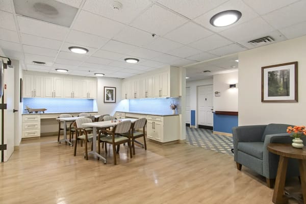 Bright dining area with tables and chairs in a senior living facility