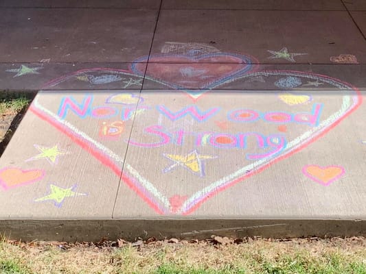 Colorful chalk drawing on pavement with heart and text