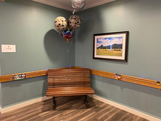 Decorated corner of an interior common area with balloons.