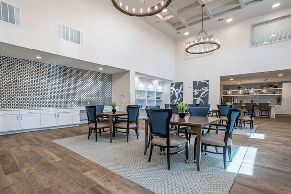 Common area with tables and chairs in a bright setting