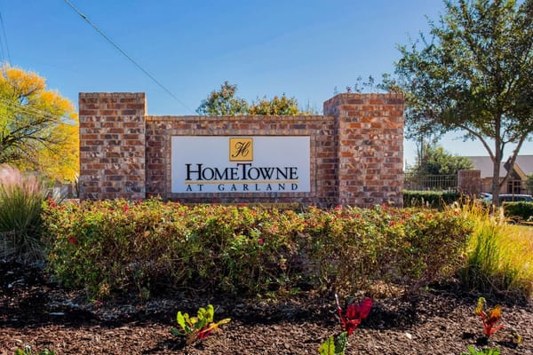 Exterior sign of HomeTowne at Garland with landscaping