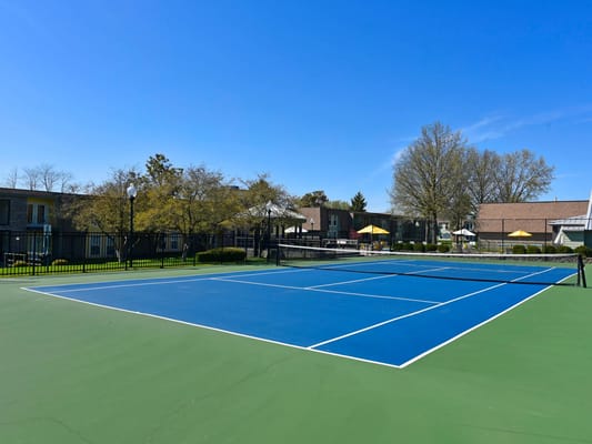 Outdoor tennis court with green and blue surfaces