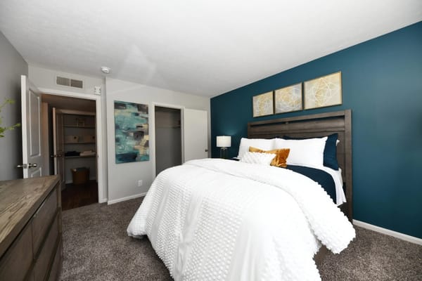 Cozy bedroom with blue accent wall and decorative art
