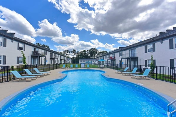 Outdoor pool area with lounge chairs and blue skies