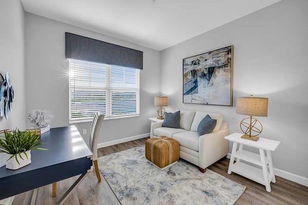 Bright and spacious resident room with a desk and sofa