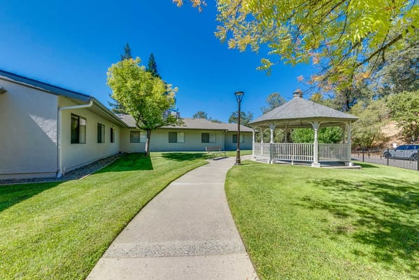 Outdoor path leading to a gazebo in a green area