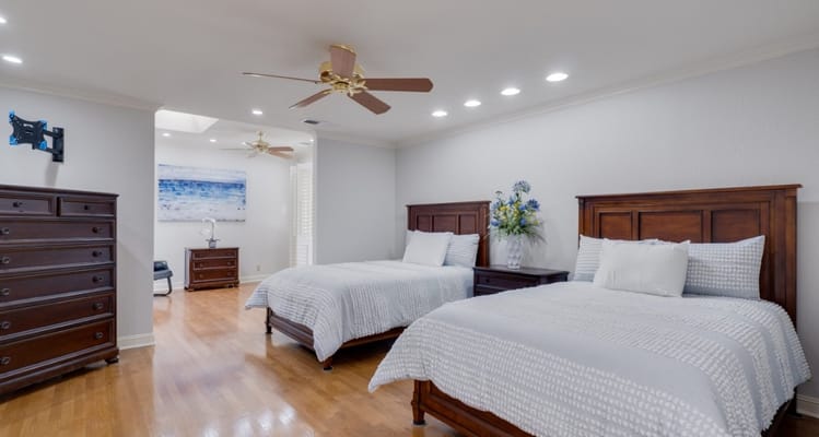 Bright bedroom with two beds and wooden furniture