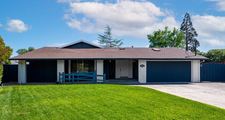 Front view of a single-story residential building with a green lawn