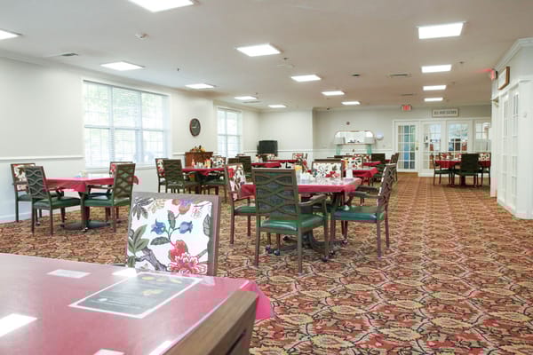 Bright dining room with floral tablecloths and ample seating