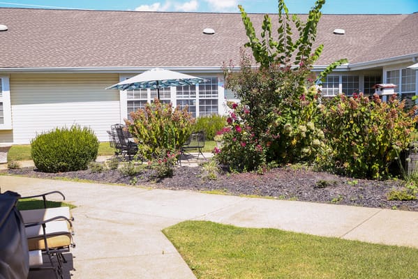 Outdoor seating area with flowers and a patio umbrella