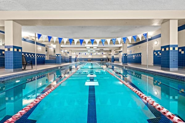 Indoor swimming pool with blue tiles and flags