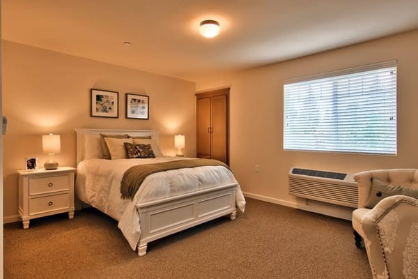 Bright and cozy resident room with a bed and armchair