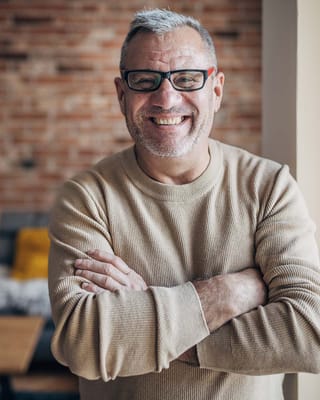 Happy senior man smiling with arms crossed