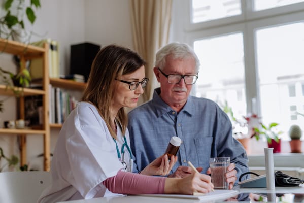 A caregiver consulting with a senior resident at a table