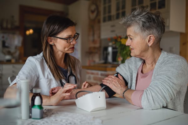 Nurse checking blood pressure of an elderly woman