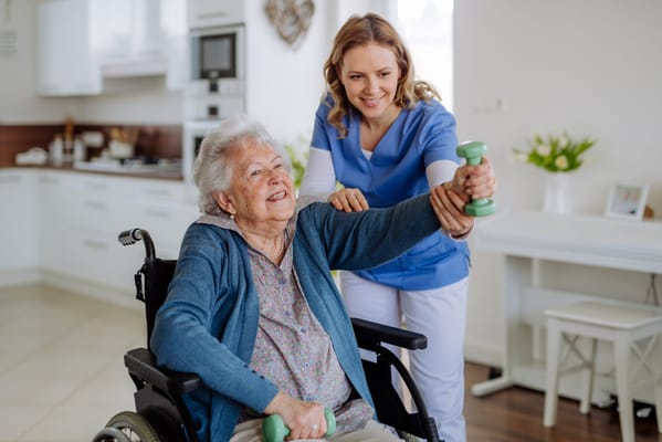 A caregiver assisting an elderly woman with weights in a room