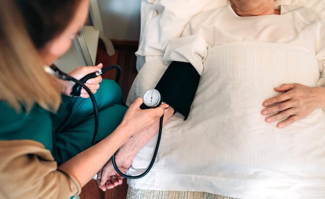 Healthcare provider monitoring a patient's blood pressure